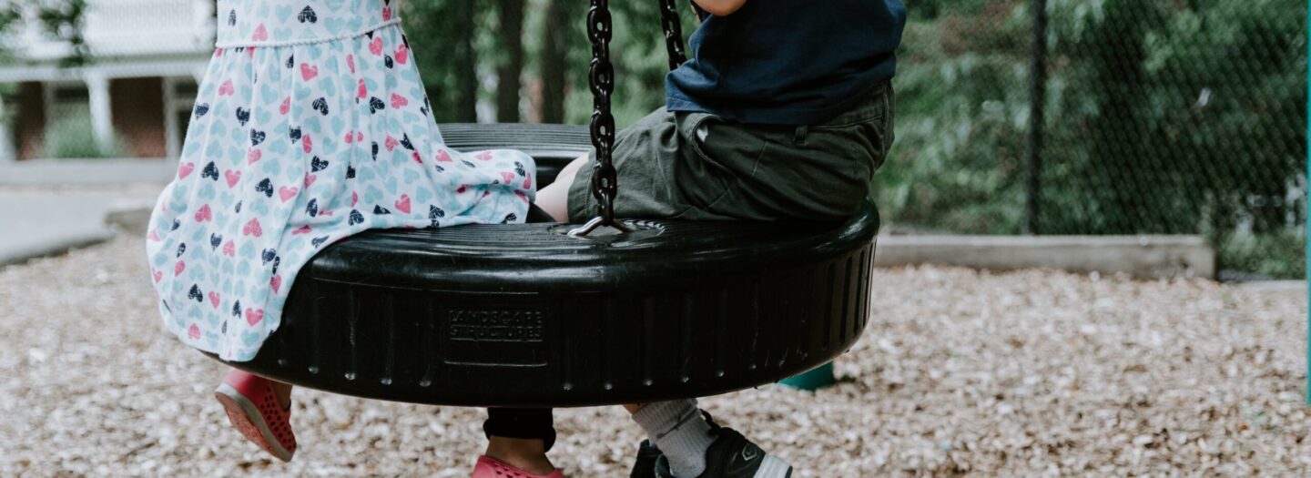 boy and girl in tire swing