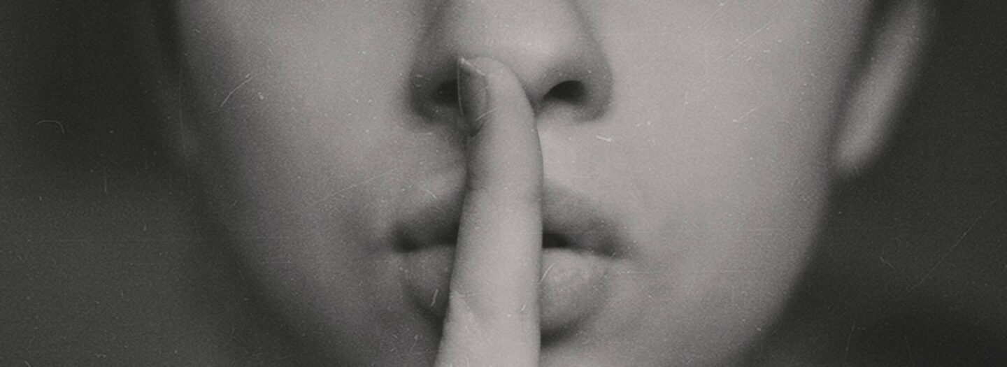 Image of a person holding their finger to their lips